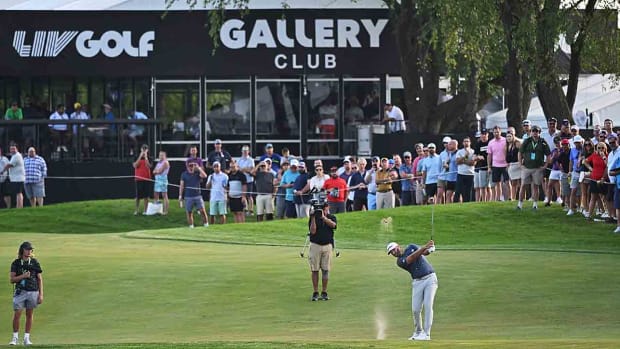 Dustin Johnson hits a shot in front of cameras at the 2022 LIV Golf Chicago event.
